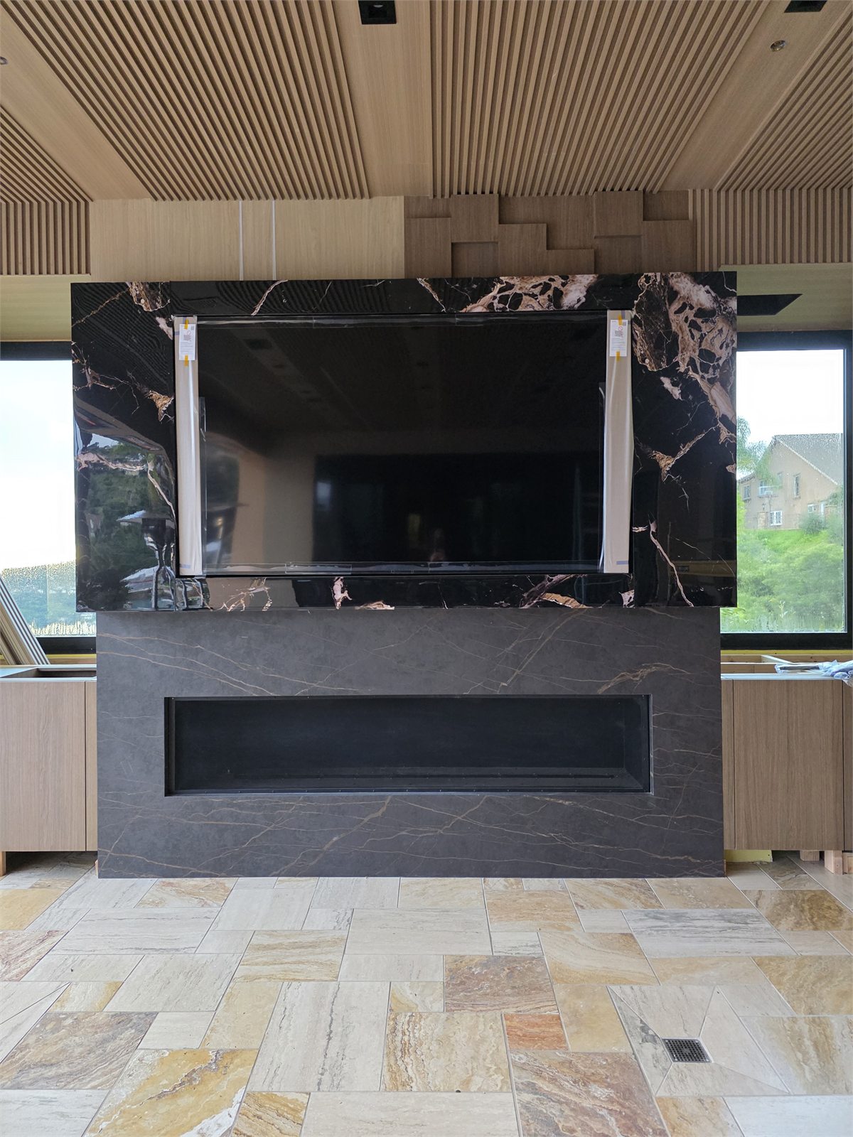 Custom fireplace and media wall with stone surround and wood slat ceiling